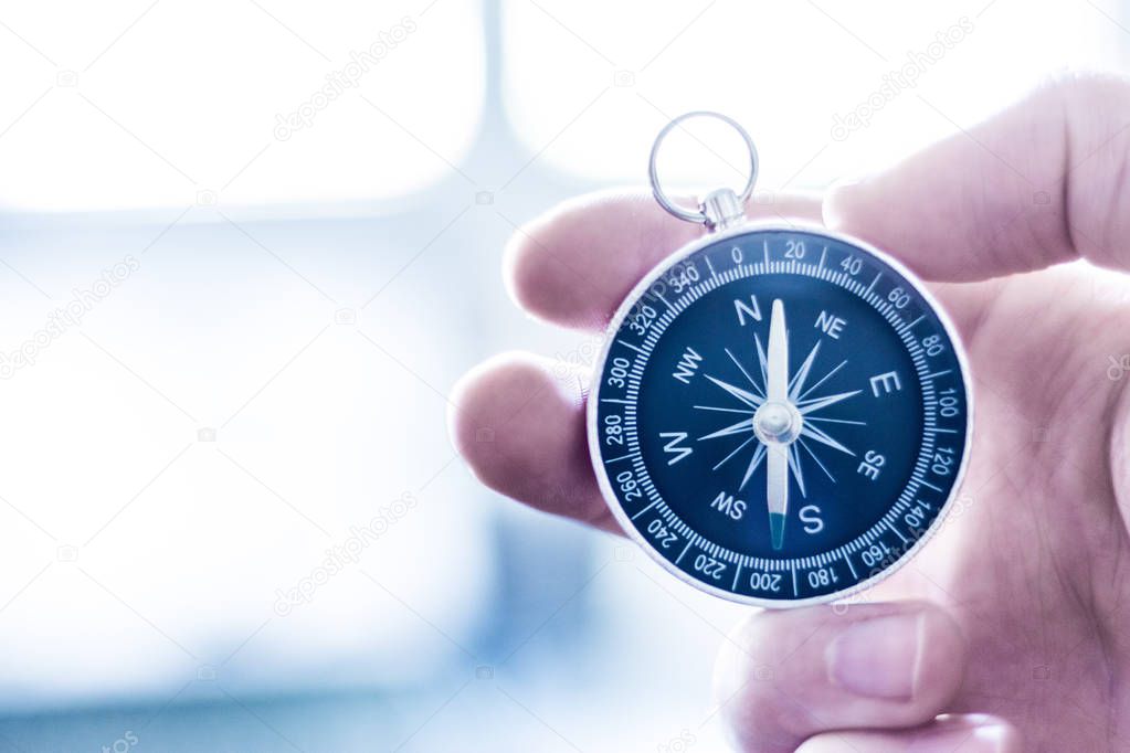 Vintage compass in mans hand, adventure and discovery concept  