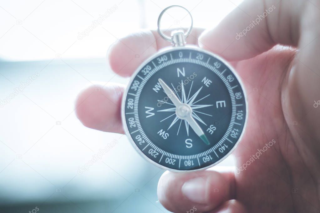 Vintage compass in mans hand, adventure and discovery concept  