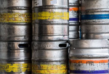 Arka planda paslı metal variller var.