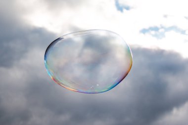 Colored soap bubble flying in a blue sky