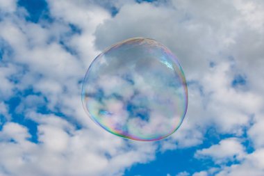 Colored soap bubble flying in a blue sky