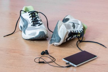 Arka planda şık spor ayakkabılar ve akıllı telefon var.