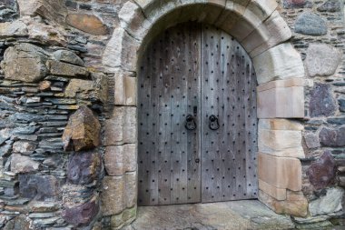 Ahşap arka plandaki metal kapı.