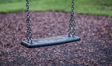 Bahçede zincirlerle boş salıncak 