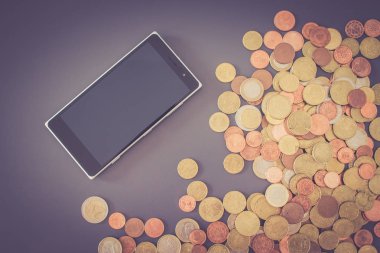 arkaplanda akıllı telefon olan bir sürü bozuk para, kapat
