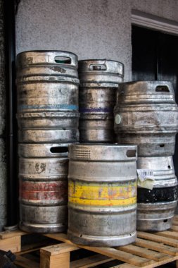 Arka planda paslı metal variller var.