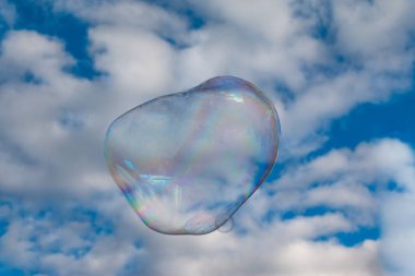 Colored soap bubble flying in a blue sky