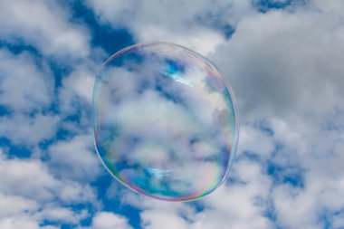 Colored soap bubble flying in a blue sky