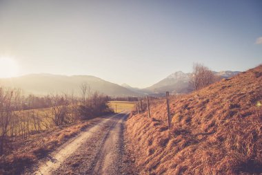 autumn road in the mountains with blue sky.