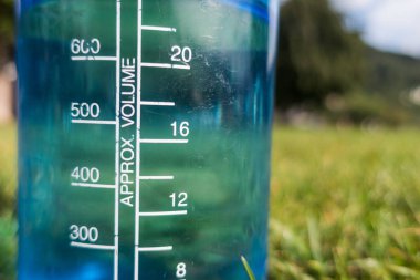 Yeşil çimlerin üzerinde bir şişe su