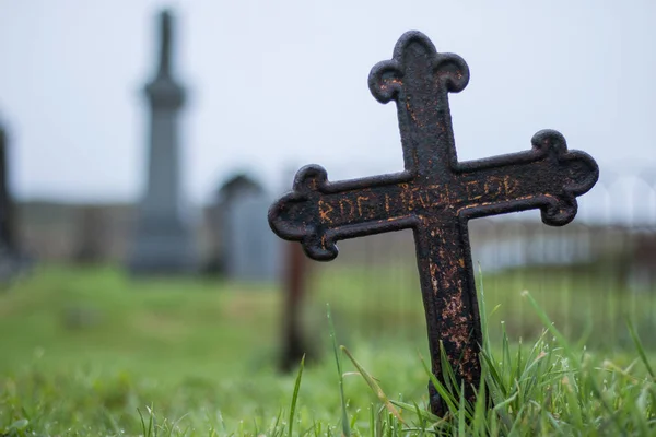 old cross on graveyard on background,close up