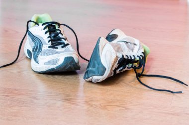 Arka planda bir çift şık spor ayakkabı.