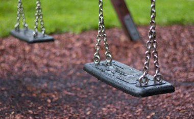 Bahçede zincirlerle boş salıncak 