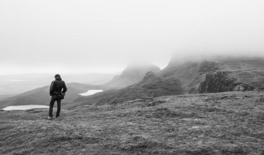 Genç adam doğal arka planda duruyor.