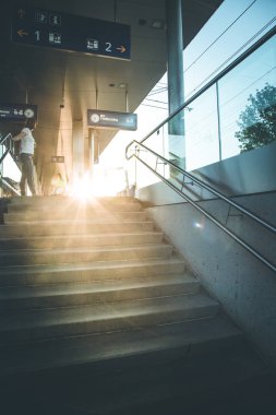 Merdivenlerde ve metro istasyonunun içinde bir kadın.