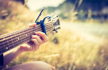 Kadın açık havada klasik gitar çalıyor.
