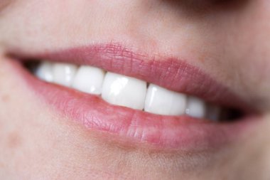 Beyaz dişli bir kadının ağzına yakın çekim.