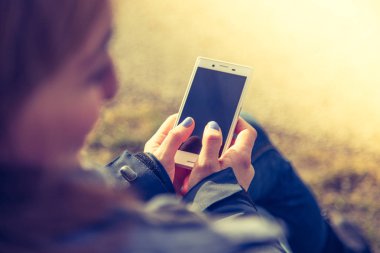 Elinde akıllı telefon kullanan kadın