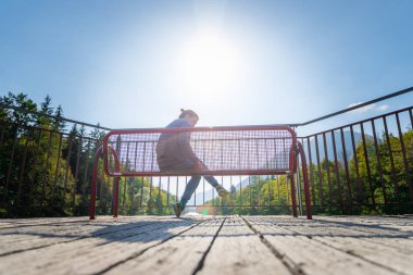 Güzel genç bir kadın bankta oturuyor. 