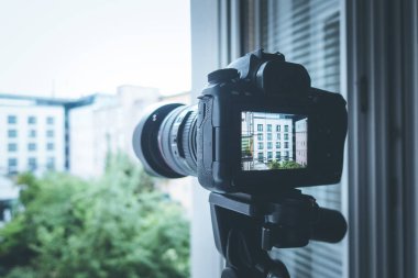 Arka planda üç ayaklı fotoğraf makinesi, kapat.
