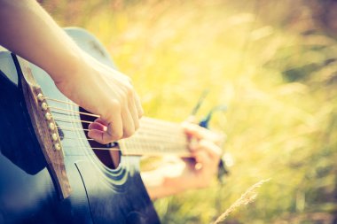 Adam açık havada klasik gitar çalıyor.