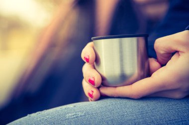 Kadınlar bardaktan sıcak su içer.