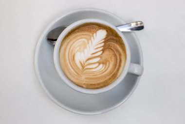 Masanın üzerinde şekilli bir fincan kahve.