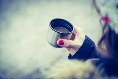 Kışın sıcak kahve içen bir kadın. 