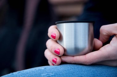 Kadınlar bardaktan sıcak su içer.