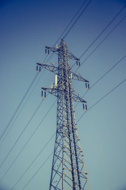 Yüksek voltaj direği. Mavi gökyüzü arkaplanındaki elektrik direği