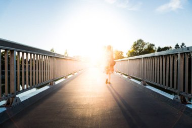 Yaz günü köprüde yürüyen bir kadın