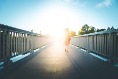 Yaz günü köprüde yürüyen bir kadın