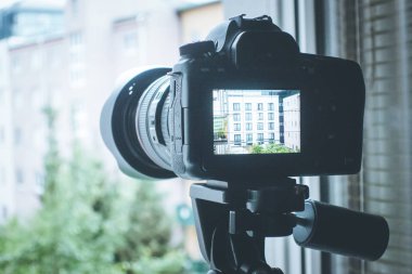 Arka planda üç ayaklı fotoğraf makinesi, kapat.