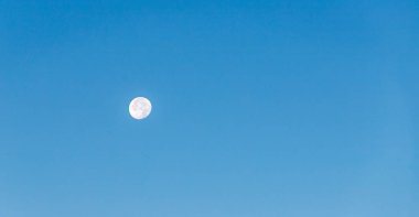 Bulutsuz mavi gökyüzünde dolunay. 