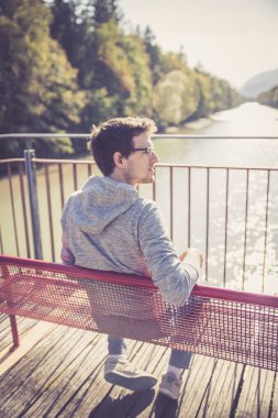 bir bankta oturan yakışıklı genç 