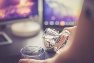 Kırpılmış insan görüntüsü bardağa su döküyor. 