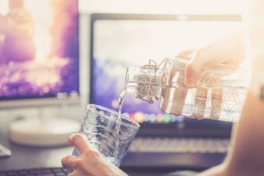 bilgisayar ve dizüstü bilgisayar erkek eli ve bir bardak su 