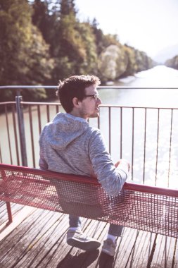 bir bankta oturan yakışıklı genç 