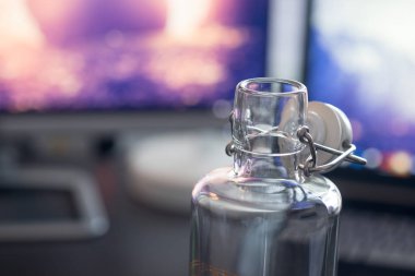 Bilgisayar ve dizüstü bilgisayar ve masada bir şişe su.