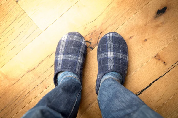 Man feet at home in winter slippers