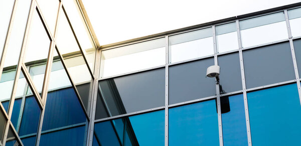 wall with reflection of the building and CCTV camera