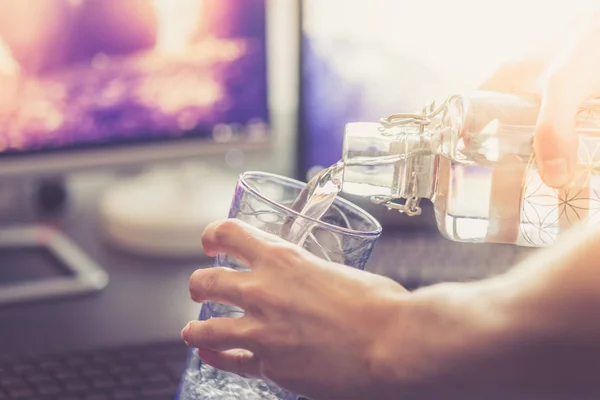 cropped shot of man pouring water in glass