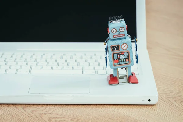 Spielzeugroboter und Laptop aus Blech — Stockbild Spielzeugroboter Und Laptop Aus Blech — Stockfoto