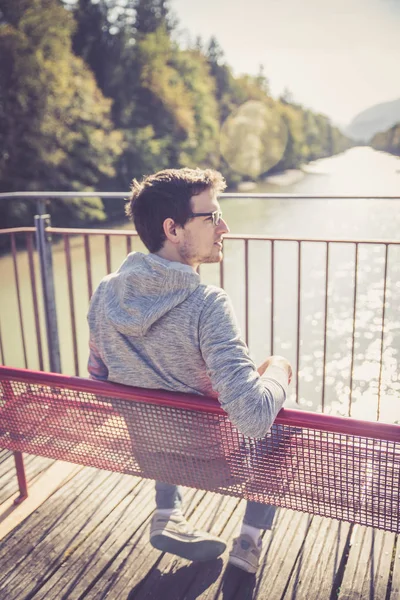 bir bankta oturan yakışıklı genç 