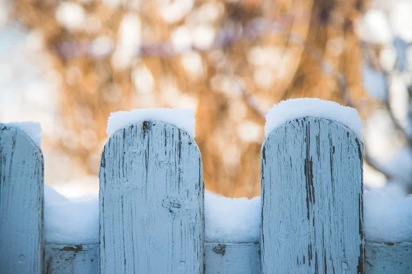 Snowing on a wooden fence, winter landscape