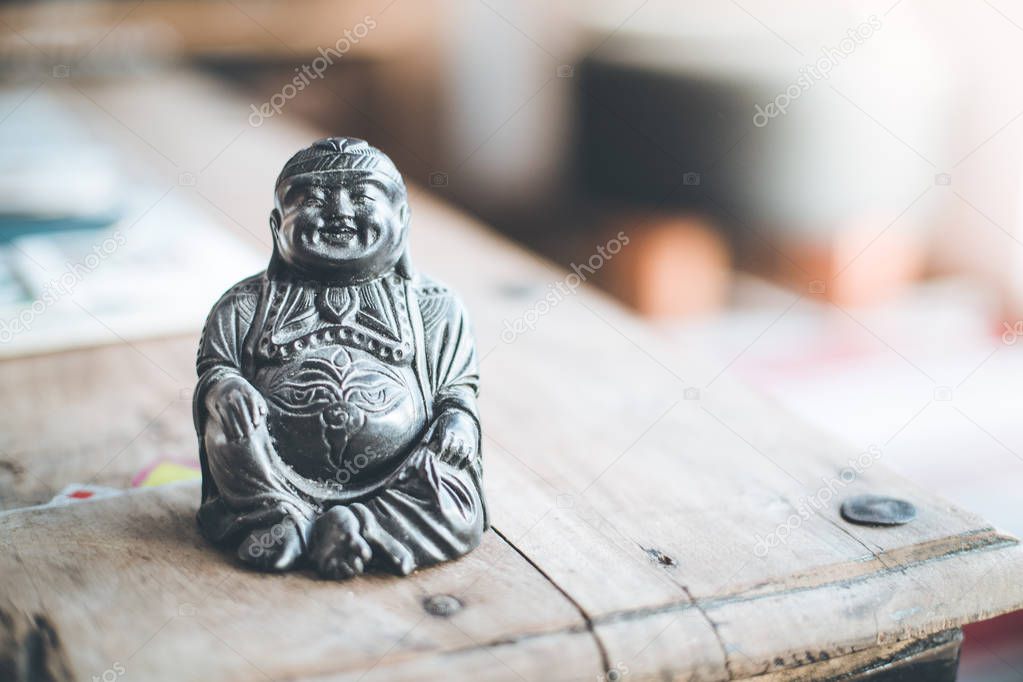 Feng shui: Buddha statue at on a table in the own living room. 