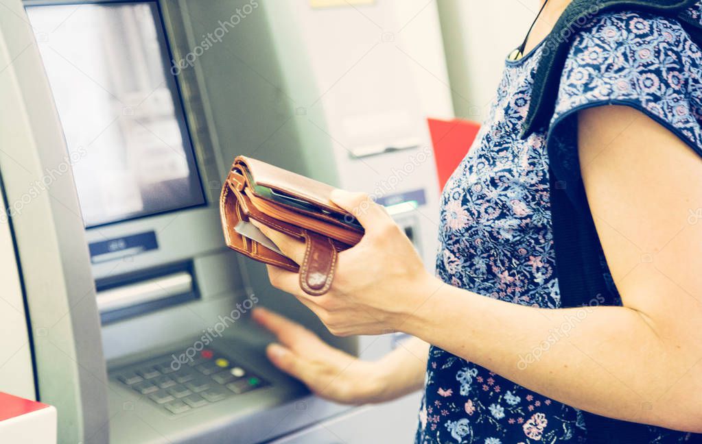 Woman with money near cash machine , closeup