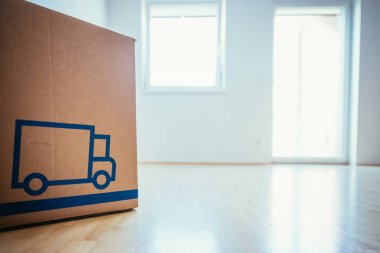 Çekil şuradan. Ahşap zemini olan temiz ve parlak bir odada karton bir kutu. Yeni bir eve taşınıyorum.. 