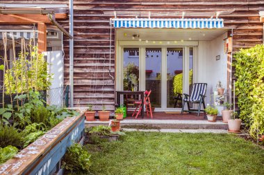 Yeşil çimenleri ve çiçekleri olan küçük bir bahçe iyi vakit geçirmek için, yaz zamanı. 