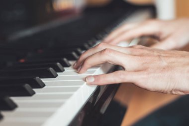 Adam evde piyano çalıyor. Piyano ve ellerin kırpılması.